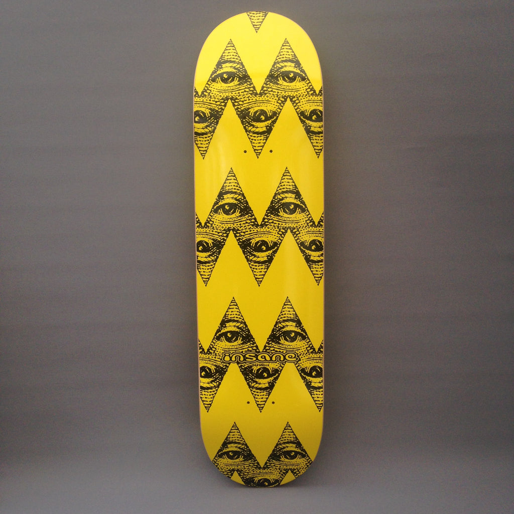 A skateboard deck featuring Ged Wells' interpretation of the yellow and black pattern on  cartoon character Charlie Brown's t-shirt. The graphic incorporates the all-seeing-eye motif