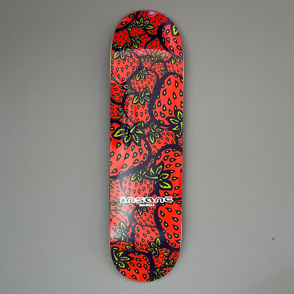 A skateboard deck with a red Insane Strawberry repeat pattern screen print